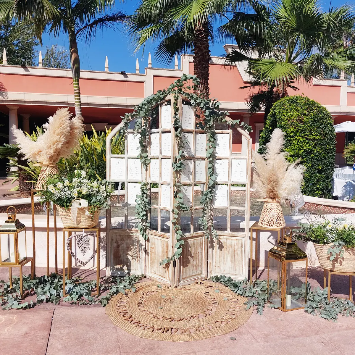 Seating plan en ventanales de madera con guirnaldas, pampas y farolillos